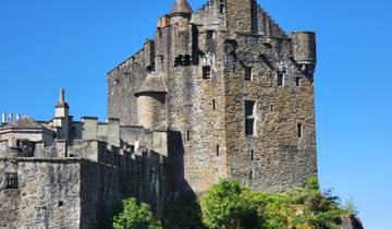 A historic stone castle under a clear blue sky.