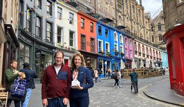 Couple posing on a colorful street with historic buildings.