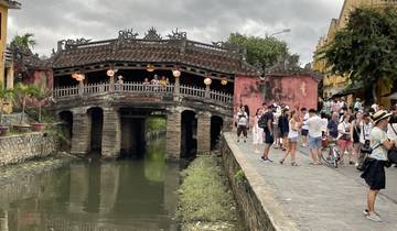 An old Japanese covered bridge with tourists.
