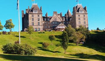 Castle-like stone building surrounded by greenery.