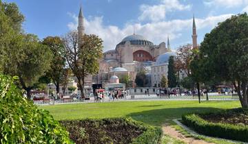 Iconic historical building with domes and minarets surrounded by gardens.