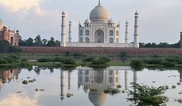 The Taj Mahal reflecting in water with a serene atmosphere.