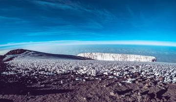 Expansive snowfield under a clear blue sky.