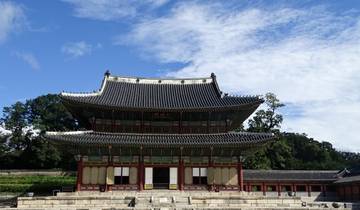 Traditional Korean palace building under a blue sky.