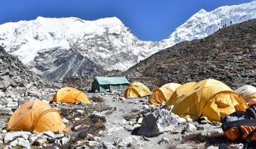 Yellow tents with snow-capped mountains in the background.
