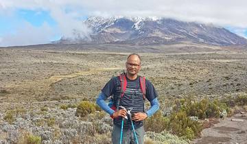 Hiker posing in front of a flat and rugged landscape.