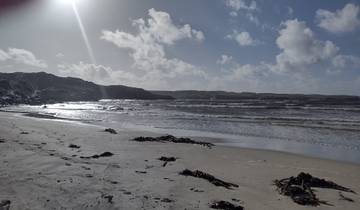 Sandy beach with waves and dramatic sky