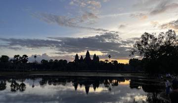Silhouette of a temple at sunrise over water.