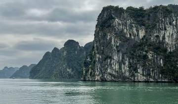View of limestone karsts over calm green waters.