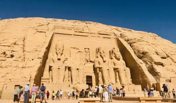 Famous rock temple facade with large statues of seated figures.