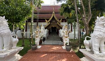 Temple entrance with statues and greenery.
