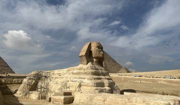 The Sphinx in Giza, Egypt with pyramids in the background.