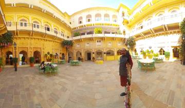 Courtyard with yellow buildings and a man standing to the right.