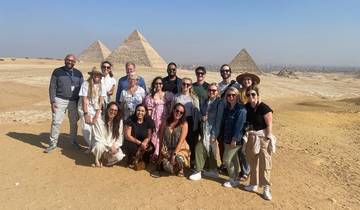 Group of people posing with the Pyramids of Giza in the background.