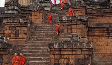 Monks in orange robes climbing ancient stone steps.