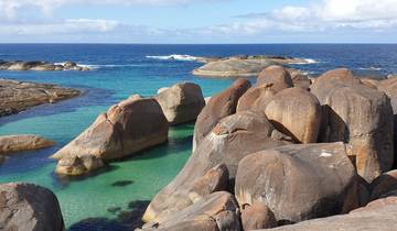 A serene coastal scene with large rocks and turquoise water.