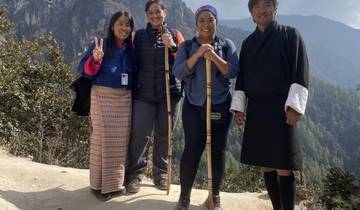 Group of people posing for a photo with mountain scenery.