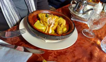 Tagine dish with vegetables and lemon on a plate.