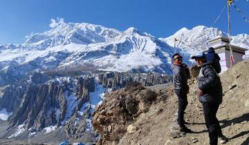 People on a mountain trail with snow-covered peaks