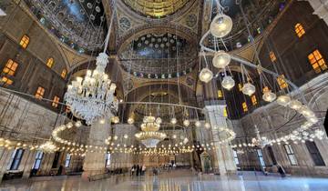 Interior of a grand mosque with elaborate chandeliers.
