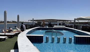 People relaxing by a pool on a boat deck.