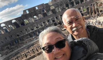 Two people taking a selfie inside a large ancient amphitheater.
