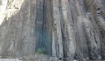Tall cliff formations over blue water.