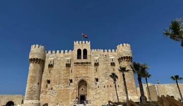 Fortress with flying national flag against clear blue sky.