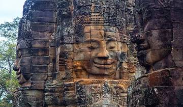 Ancient stone carvings of faces on a large ruin.