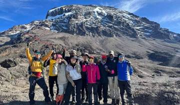 Group of hikers standing in front of Mount Kilimanjaro.