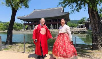 Couple wearing traditional Korean hanbok in front of a historic palace.