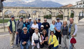 Group of people posing in front of ancient arches.