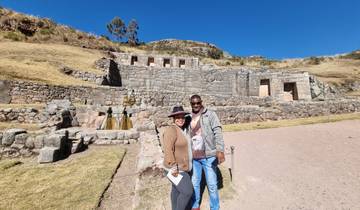 Two people standing in front of ancient ruins.