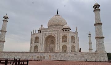 Iconic white marble mausoleum with minarets and people.