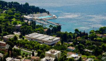 Aerial view of a coastal town with lush greenery and buildings near the sea.