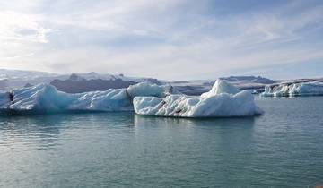 Icebergs floating in a calm glacial lagoon.