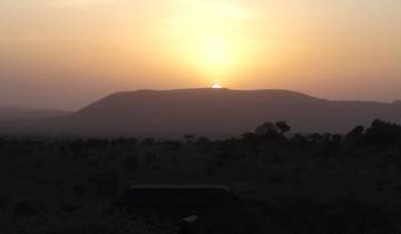 Scenic sunset over a hilly landscape.