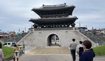 Traditional Korean gate with people walking underneath.