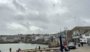 Coastal town with buildings by the harbor under a gray sky.