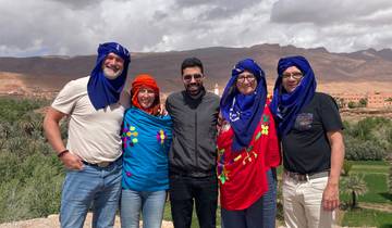 Group of people wearing traditional clothing with a valley in the background.