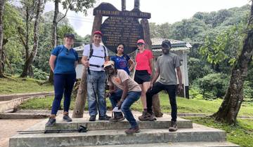Group of hikers posing at Kilimanjaro National Park entrance.