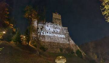 Illuminated castle wall at night with a Halloween message projected.
