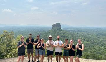Group of people posing with Sigiriya Rock in the background.