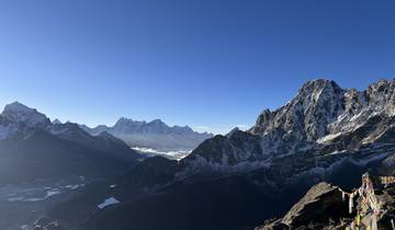 Expansive view of snow-covered mountains under a clear sky.