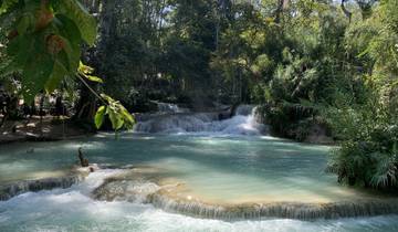 A beautiful turquoise waterfall surrounded by lush greenery.
