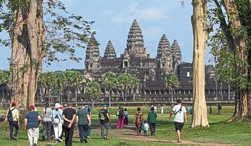 Group of people walking towards the Angkor Wat temple.