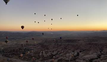 Hot air balloons floating over Cappadocia at sunrise.