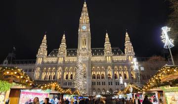 Rathaus decorated for Christmas market with illuminated stalls.