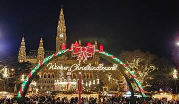 Wiener Christkindlmarkt entrance with festive lights at night.