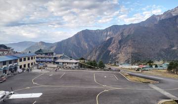 Lukla airport with airplanes and mountainous backdrop.